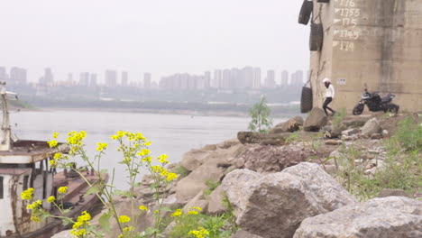 a woman riding a motorcycle came to the riverbank to blow wind