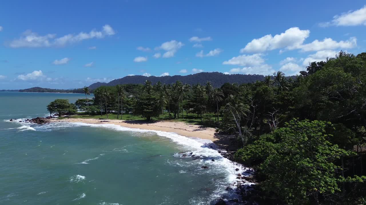 Aerial drone view rising above dense green jungle to reveal remote secluded beaches on Koh Lanta Thailand, featuring crystal clear water, tropical coastline and pristine travel destination paradise