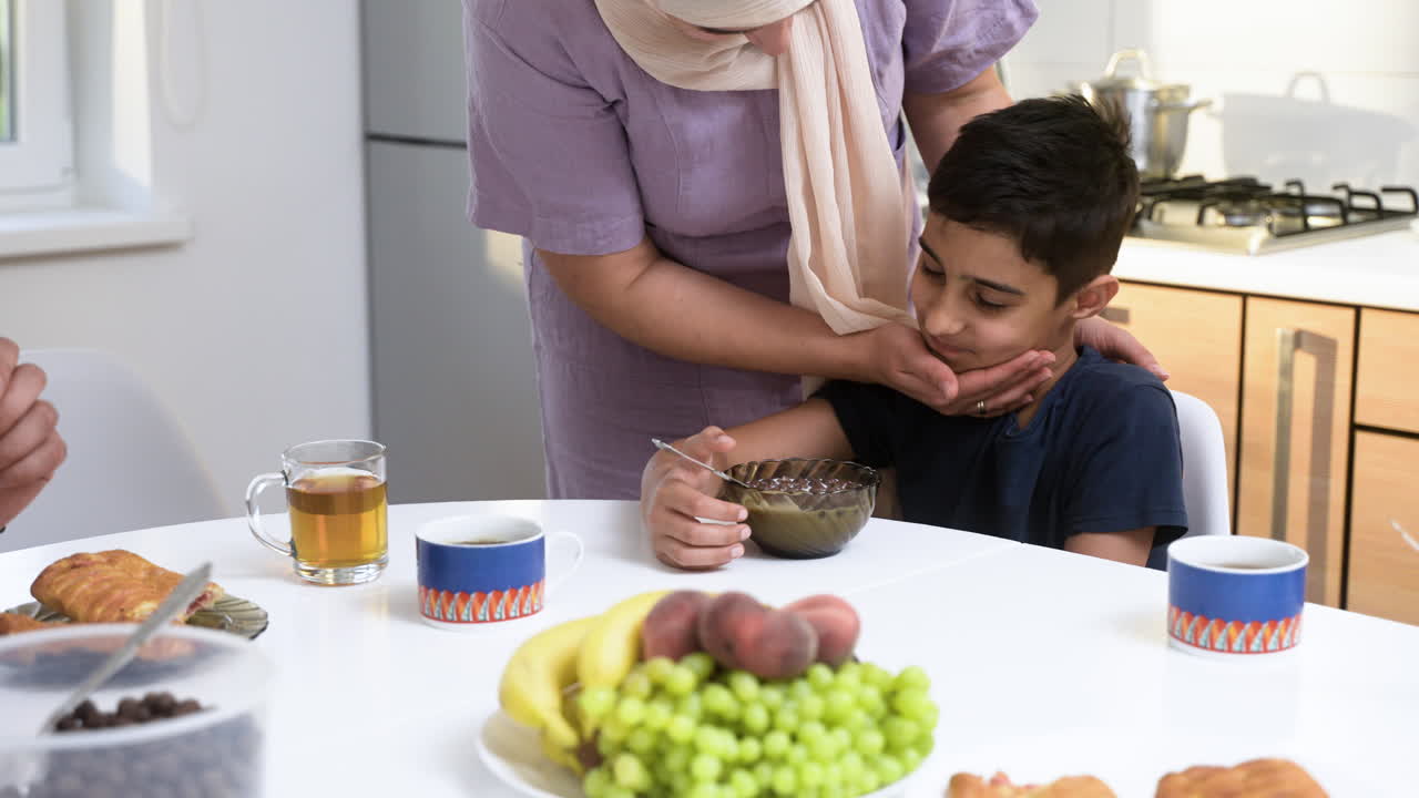 Islamilainen poika syömässä aamiaista