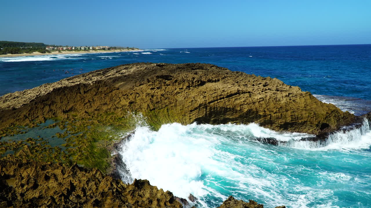Still shot of waves crashing into rocks at Playa Jobos, in Puerto Rico.