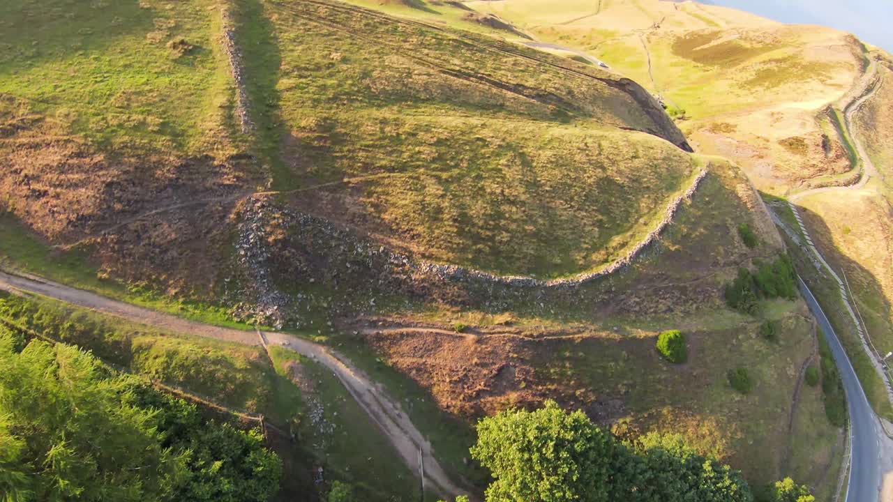 fpv drone disparó justo sobre la cresta de la alta montaña en los hermosos colores otoñales de color naranja en el distrito de los picos en el norte de inglaterra y luego giró 180 grados en un día soleado