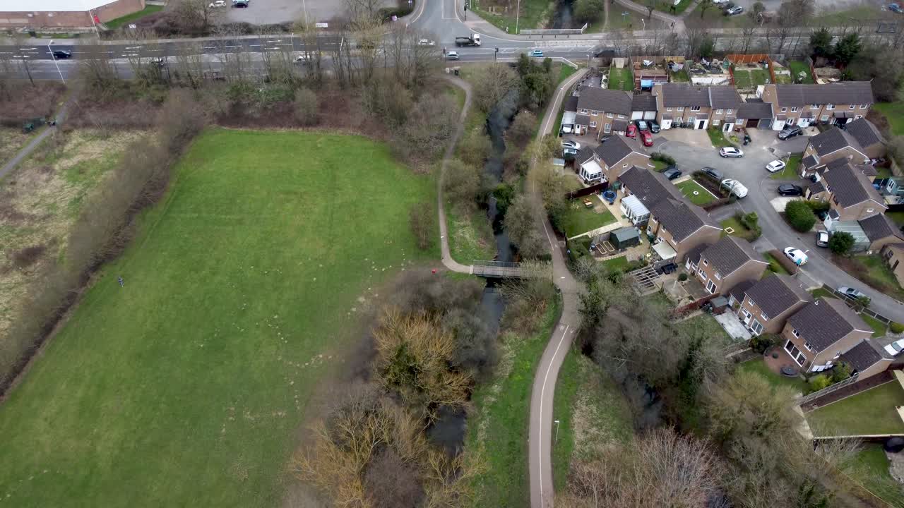 Aerial view of a river in a park and a large housing estate