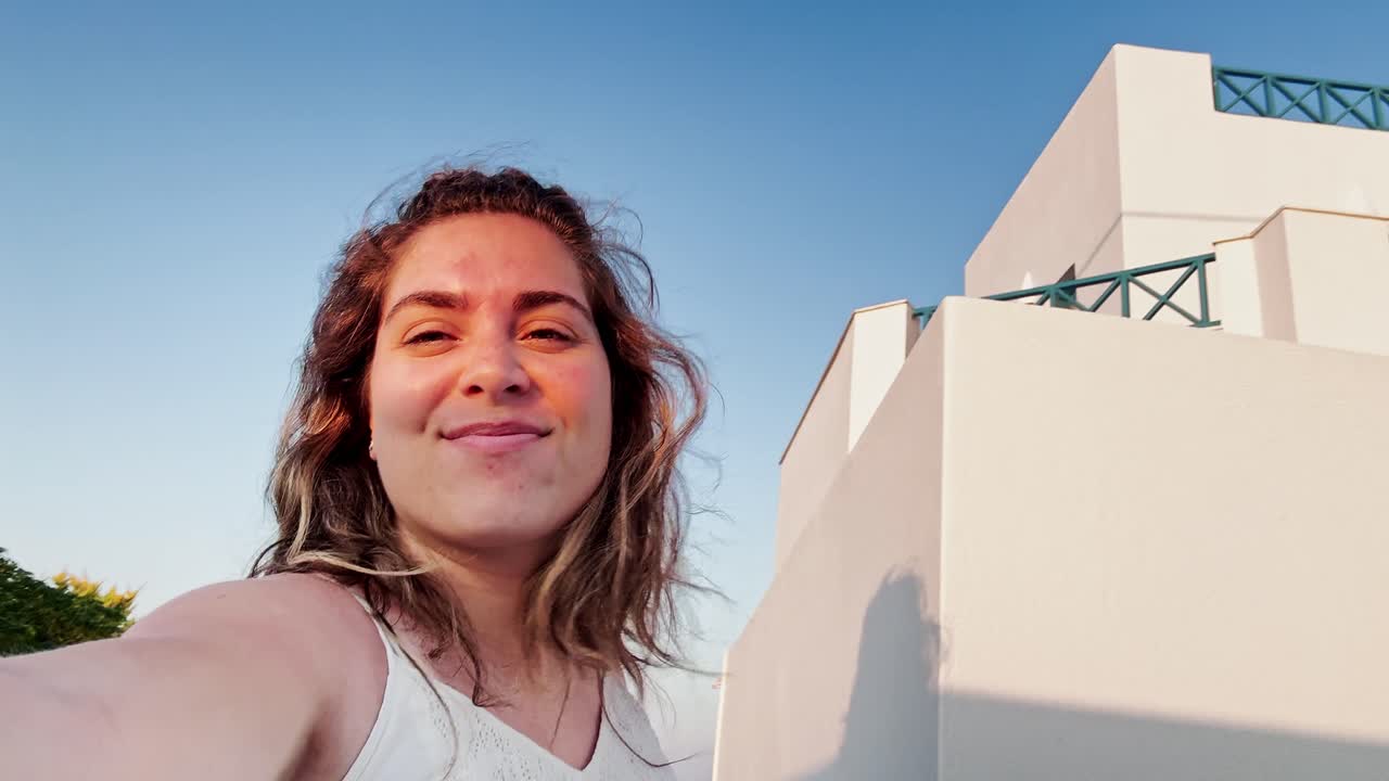 Smiling Woman in Santorini, Greek Flag in Background