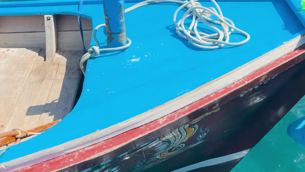 A vibrant boat deck featuring ropes, wooden planks, and colorful supplies under bright sunlight.