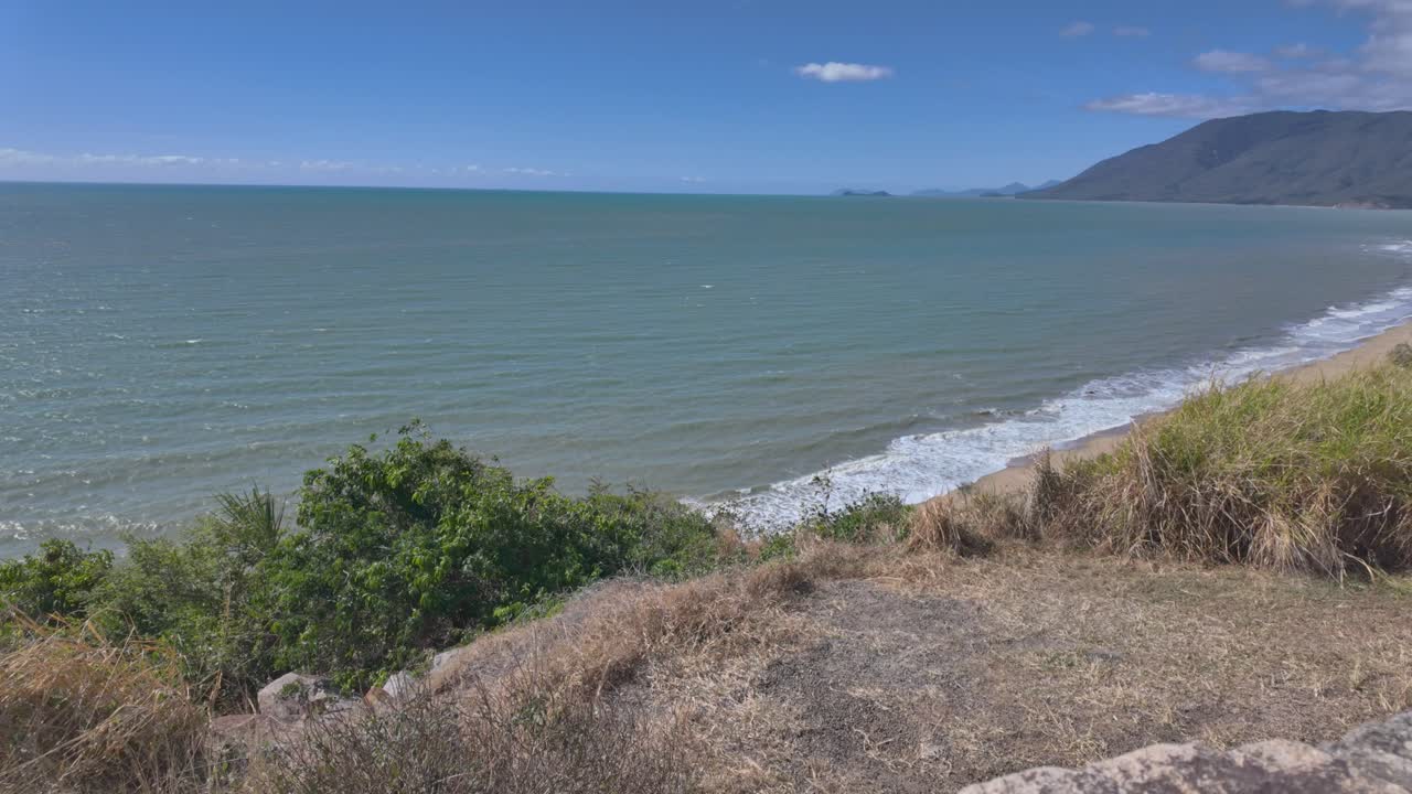 Sweeping footage of a beautiful tropical curved beach filmed from a view point in North Queensland in Australia