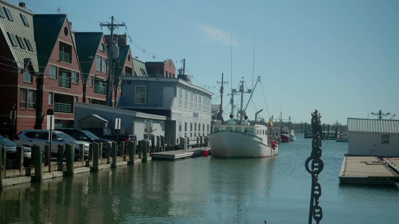 A waterfront view with fishing large fishing boat docked along the calm water and historic surroundings