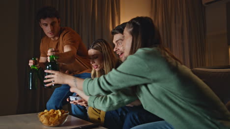 gambling people playing gamepads at evening gathering close up. friends excited