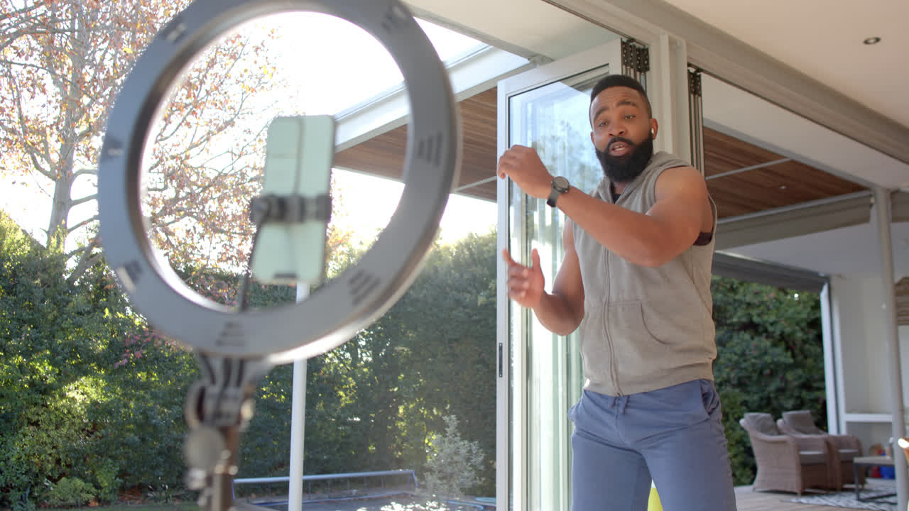 vlogger de fitness afroamericano aconsejando y filmando en casa, cámara lenta