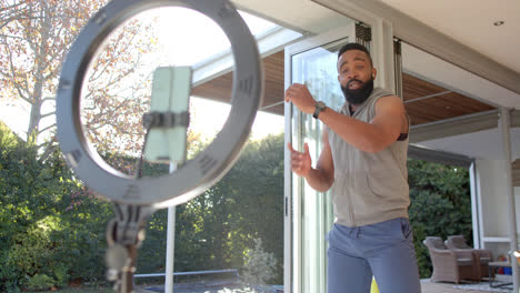 African-american-male-fitness-vlogger-advicing-and-filming-at-home,-slow-motion