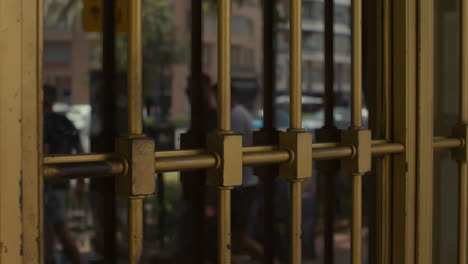 a close-up of a metal security gate on a glass door