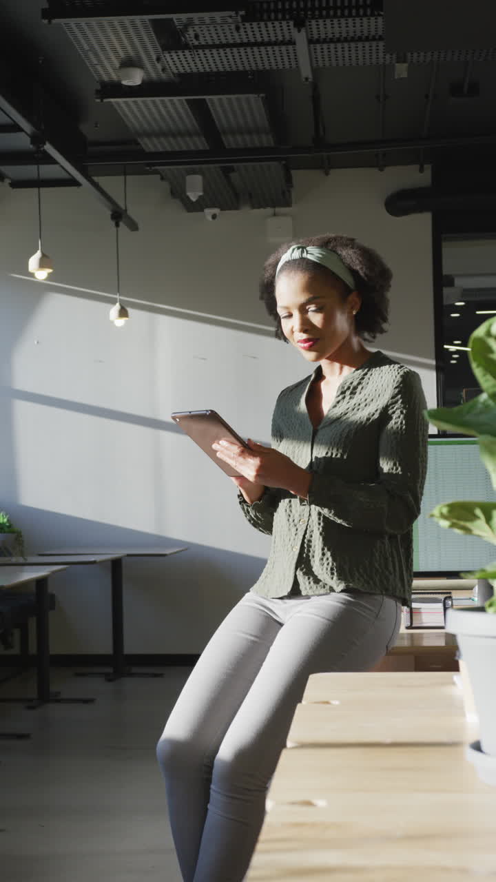 Video verticale di una felice donna d'affari afroamericana che guarda la telecamera in ufficio.