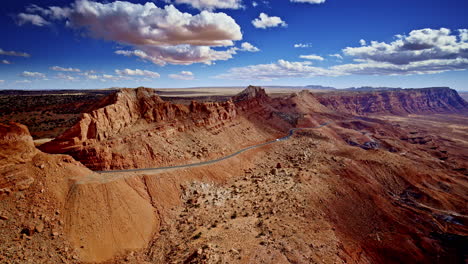 drone shot looking at the crazy pass carved through red rock mountains near page arizona