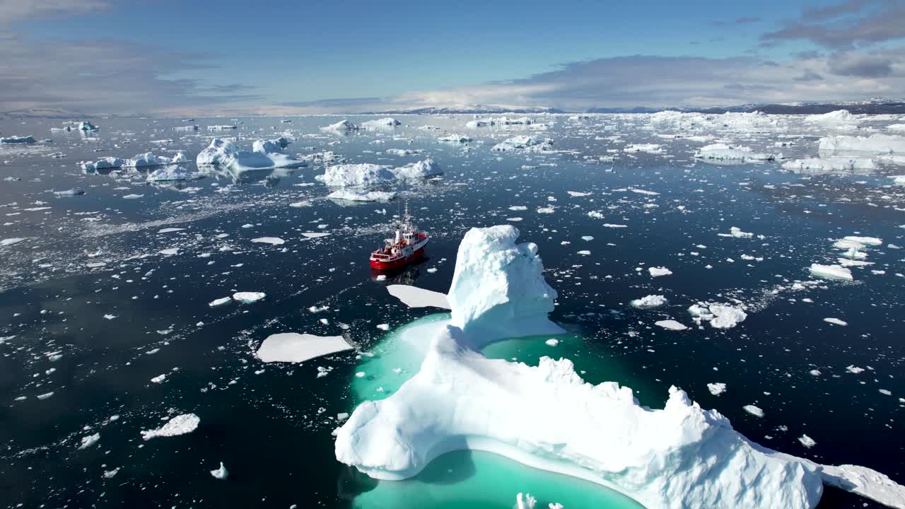 거대한 녹는 빙산 주위를 항해하는 배의 아름다운 공중