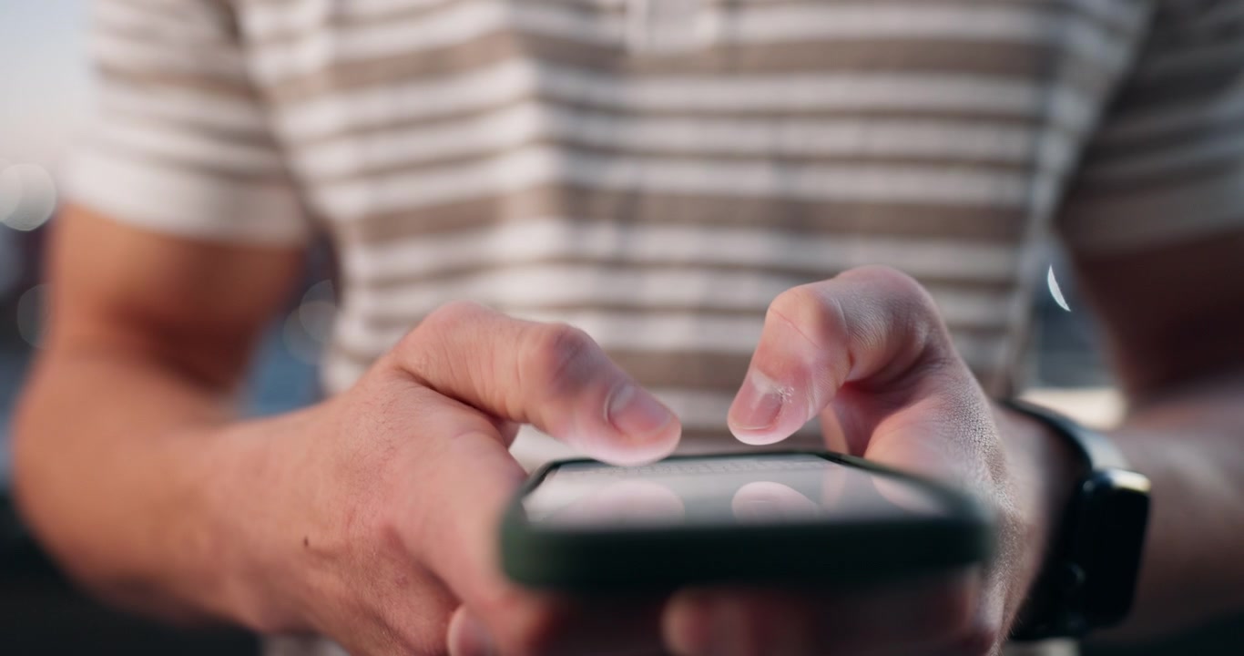 Close-up of a Man Using a Smartphone Outdoors