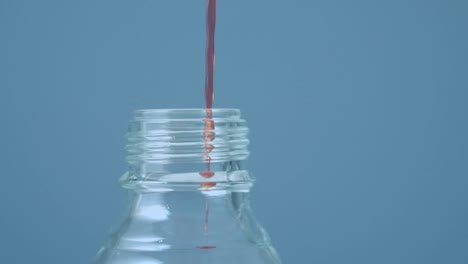 Animation-of-red-shapes-over-liquid-pouring-into-bottle