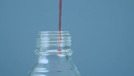 animación de formas rojas sobre líquido que se vierte en la botella