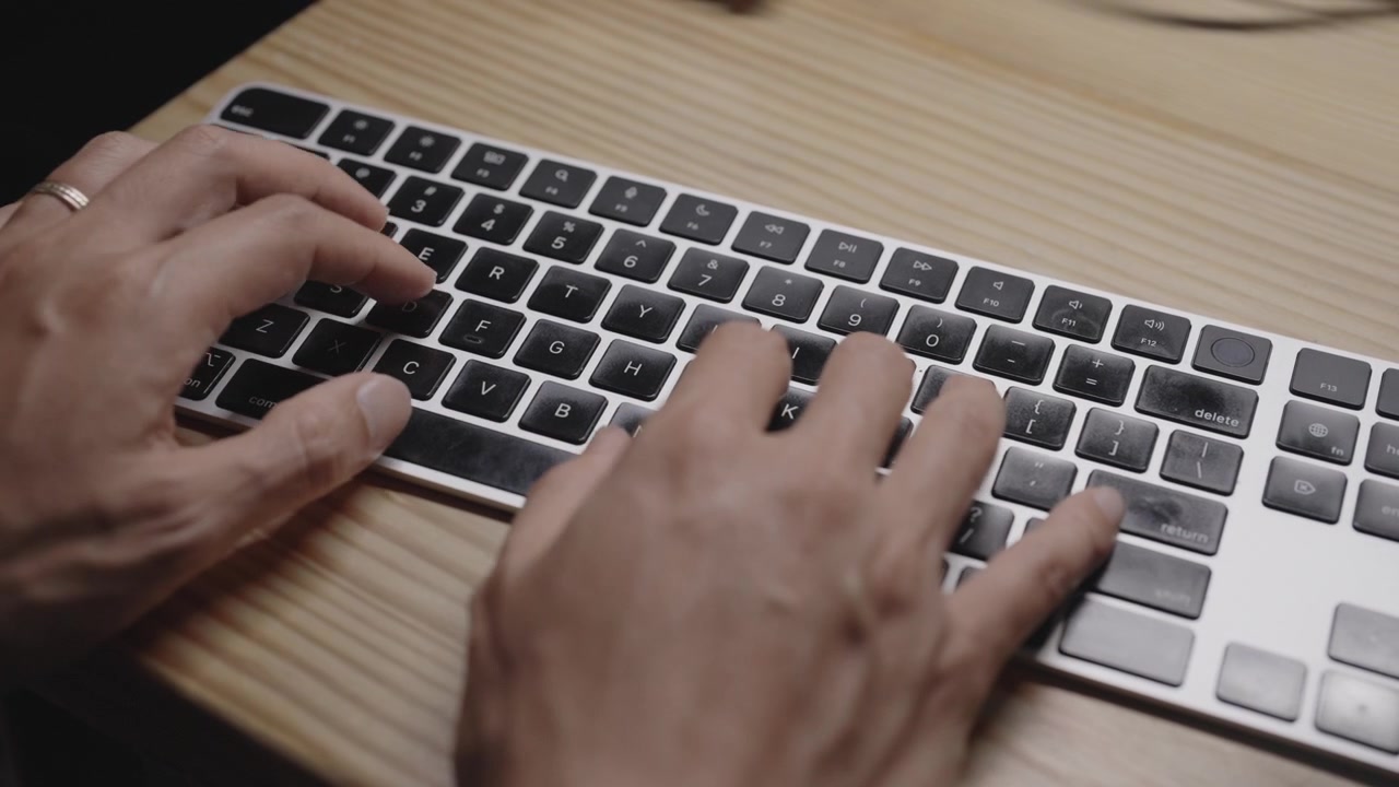 Close-up de mãos digitando em um teclado sem fio moderno