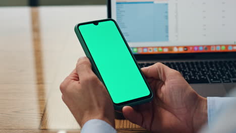 Man-fingers-holding-mockup-telephone-workplace.-Businessman-reading-smartphone