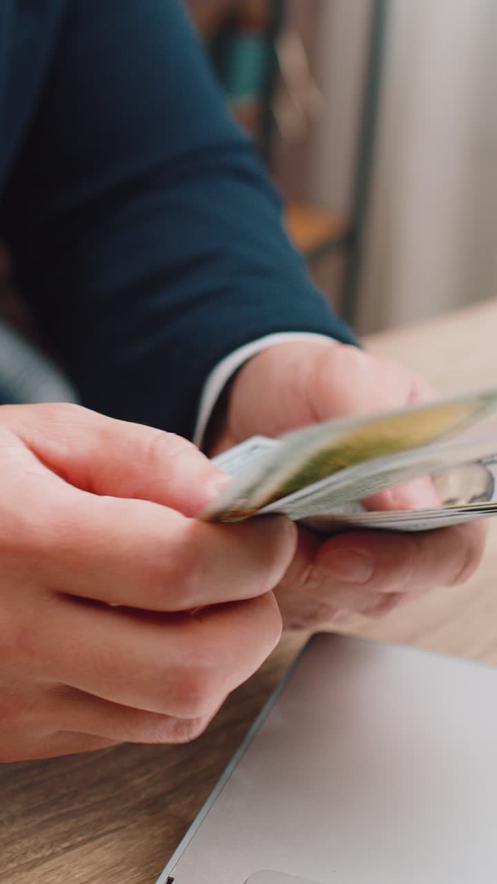 Closeup of hands of businessman counting money cash use laptop earning profit success contract
