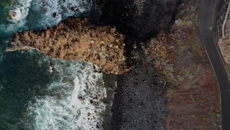 view down to the dark shores of the island washed by the waves of the sea, hierro island, canary island, spain