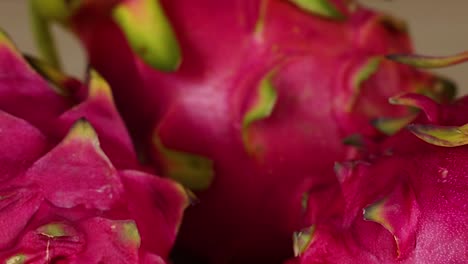 detailed view of dragon fruit skin showcasing its vibrant pink color and green tips.
