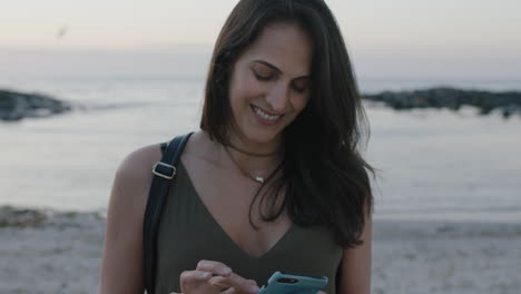 retrato de una mujer elegante y encantadora enviando mensajes de texto con un teléfono inteligente en una hermosa playa tranquila