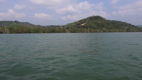 agua tranquila y colinas verdes bajo un cielo azul