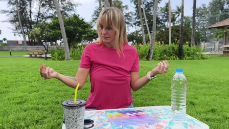 woman beading outdoors in a park