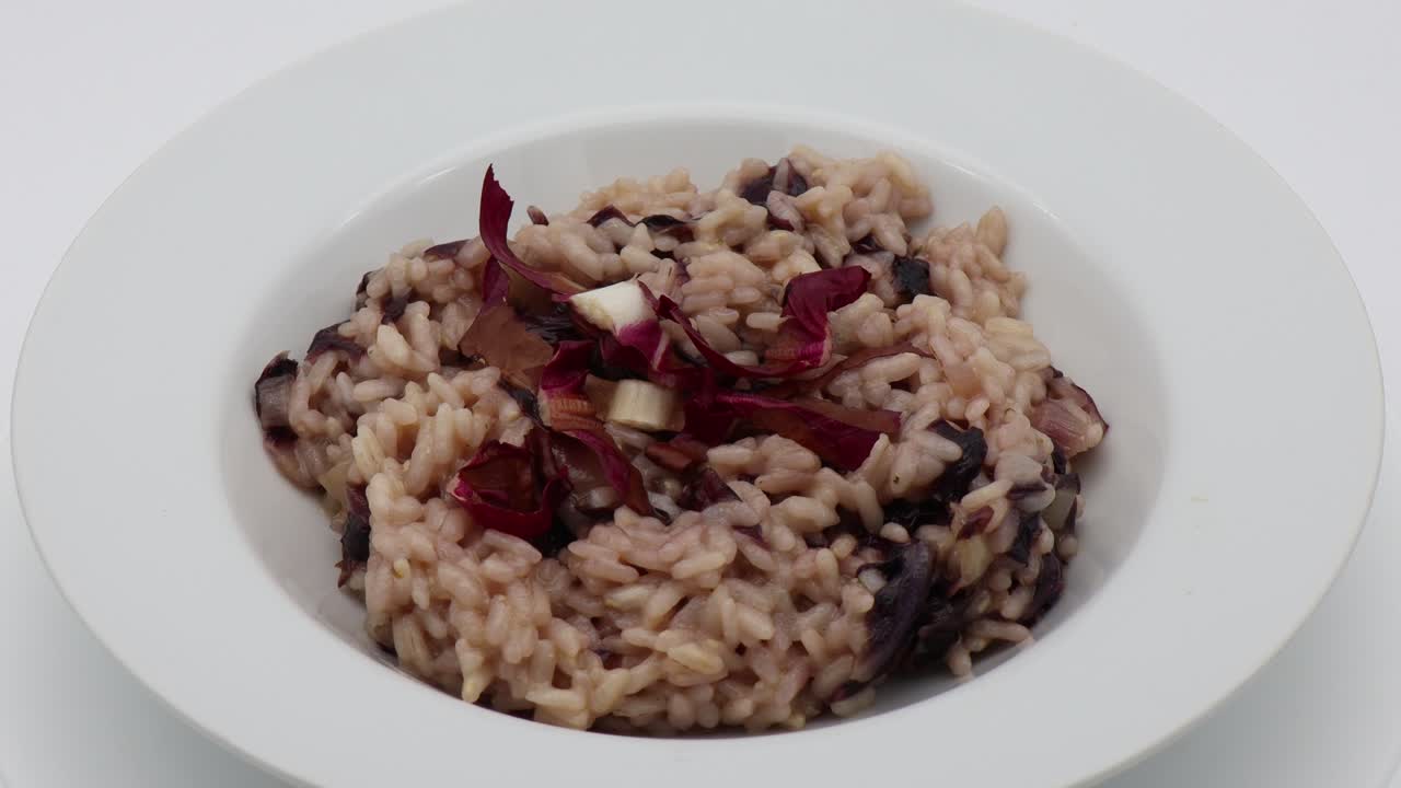risotto con radicchio rojo en un plato negro