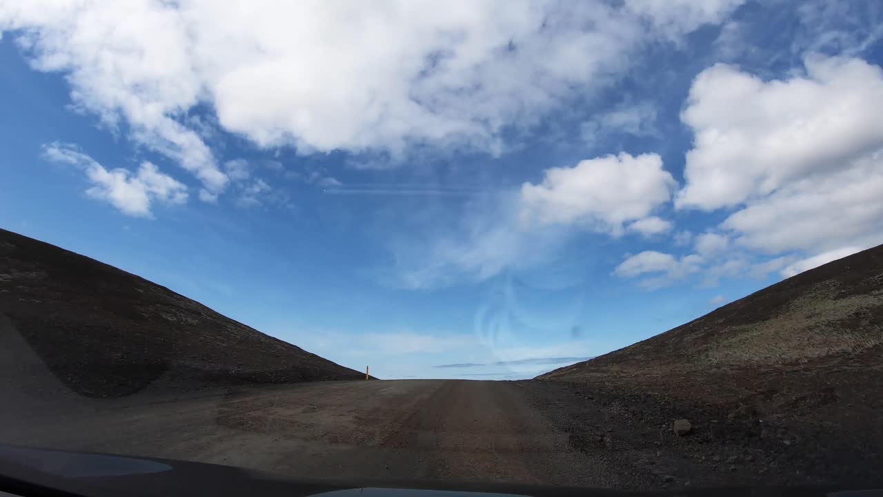 Views of arid mountains in iceland seen from inside a car