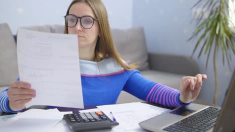 mujer usando calculadora para calcular facturas domésticas en el hogar, haciendo papeleo para pagar impuestos
