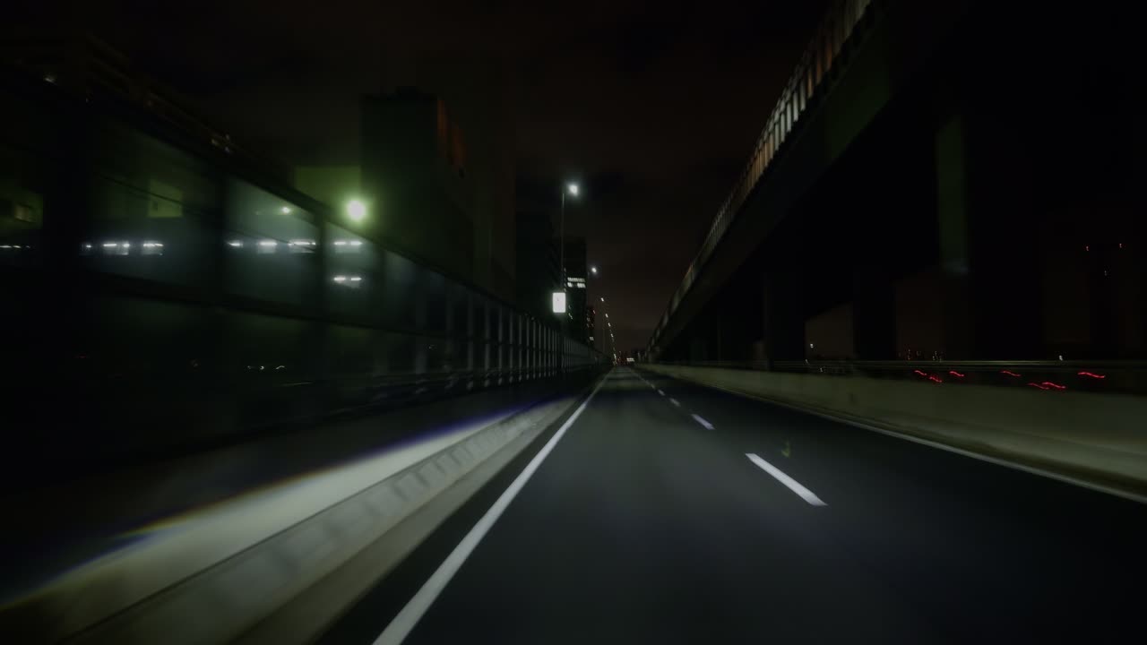 Nighttime Highway in Tokyo’s Expanding Cityscape A view from the car as it cruises Tokyo’s new territories at night, where urban lights and winding roads meet