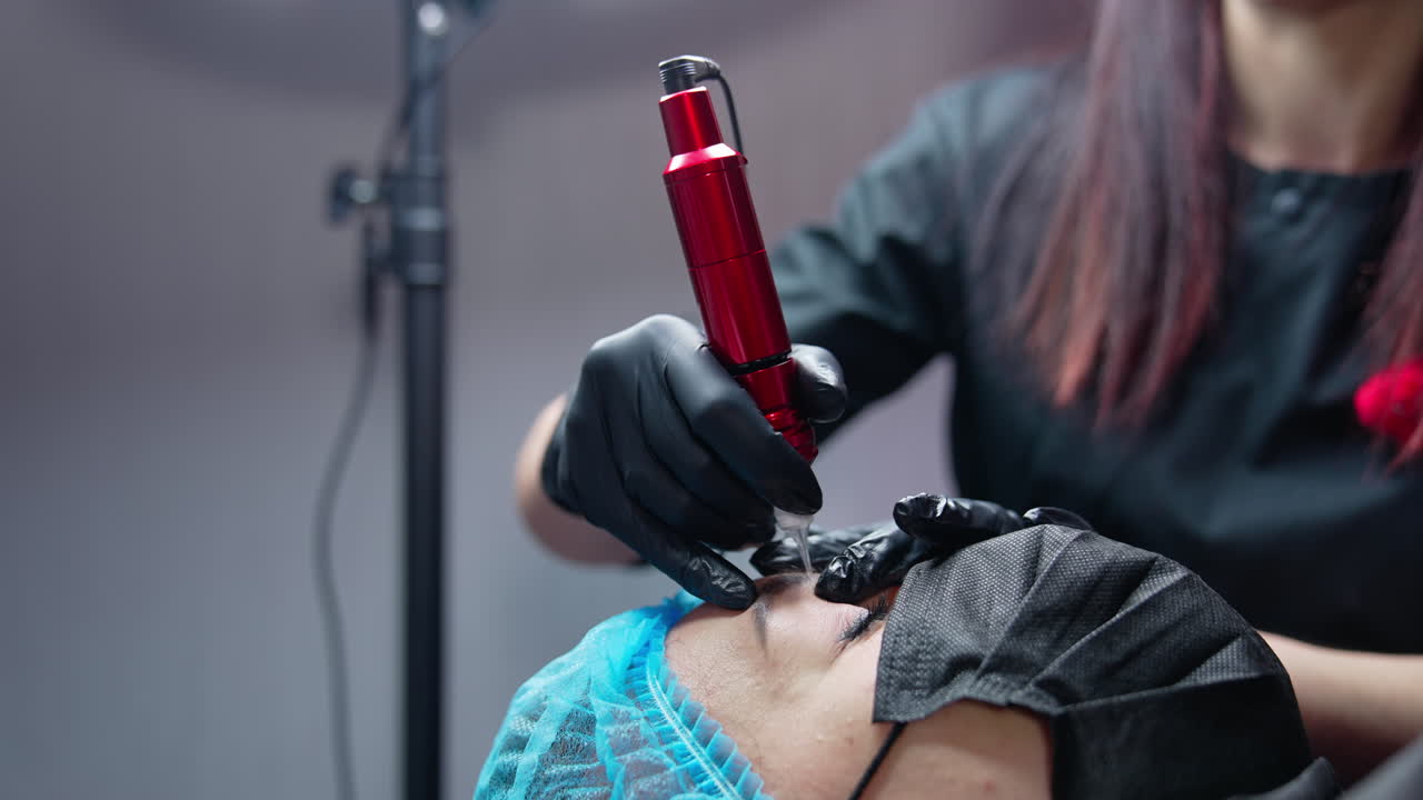 Cosmetologist work with machine. Cosmetologist using eyebrow tattoo machine