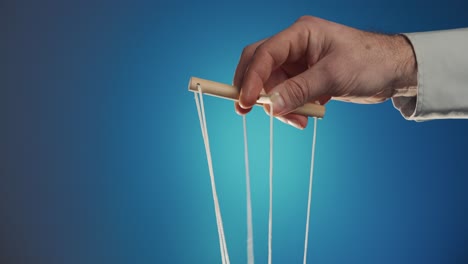 Hand holding puppet strings