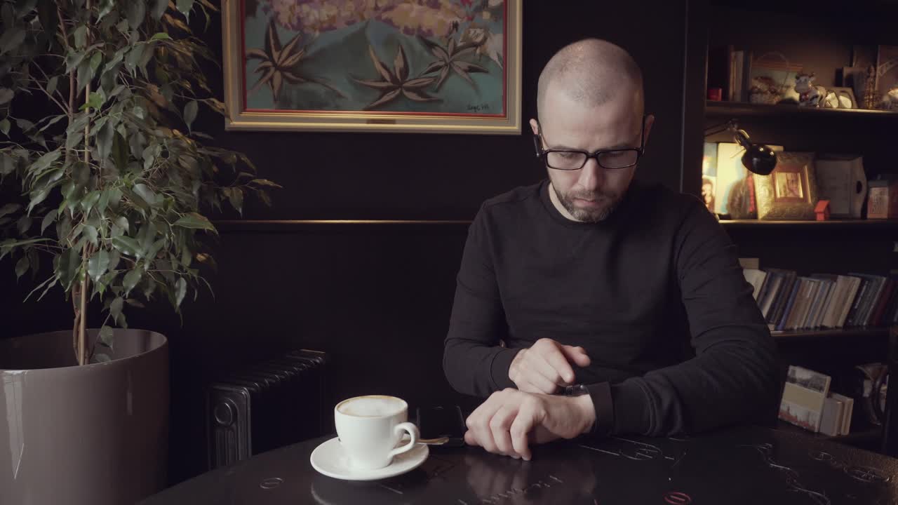 Man Checking Time in a Cafe