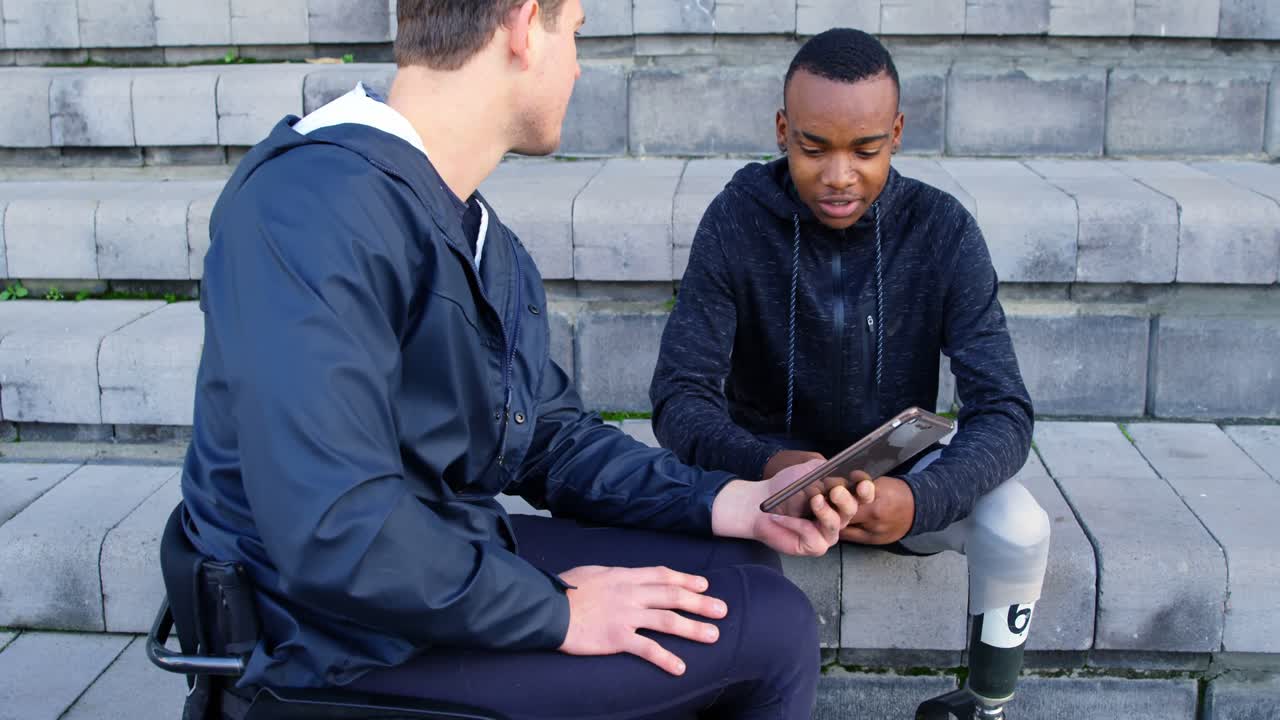 두 명의 장애인 육상 선수들이 디지털 태블릿 4k를 통해 토론하고 있습니다.