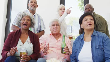 personas mayores felices y diversas viendo televisión con cerveza en el hogar de ancianos