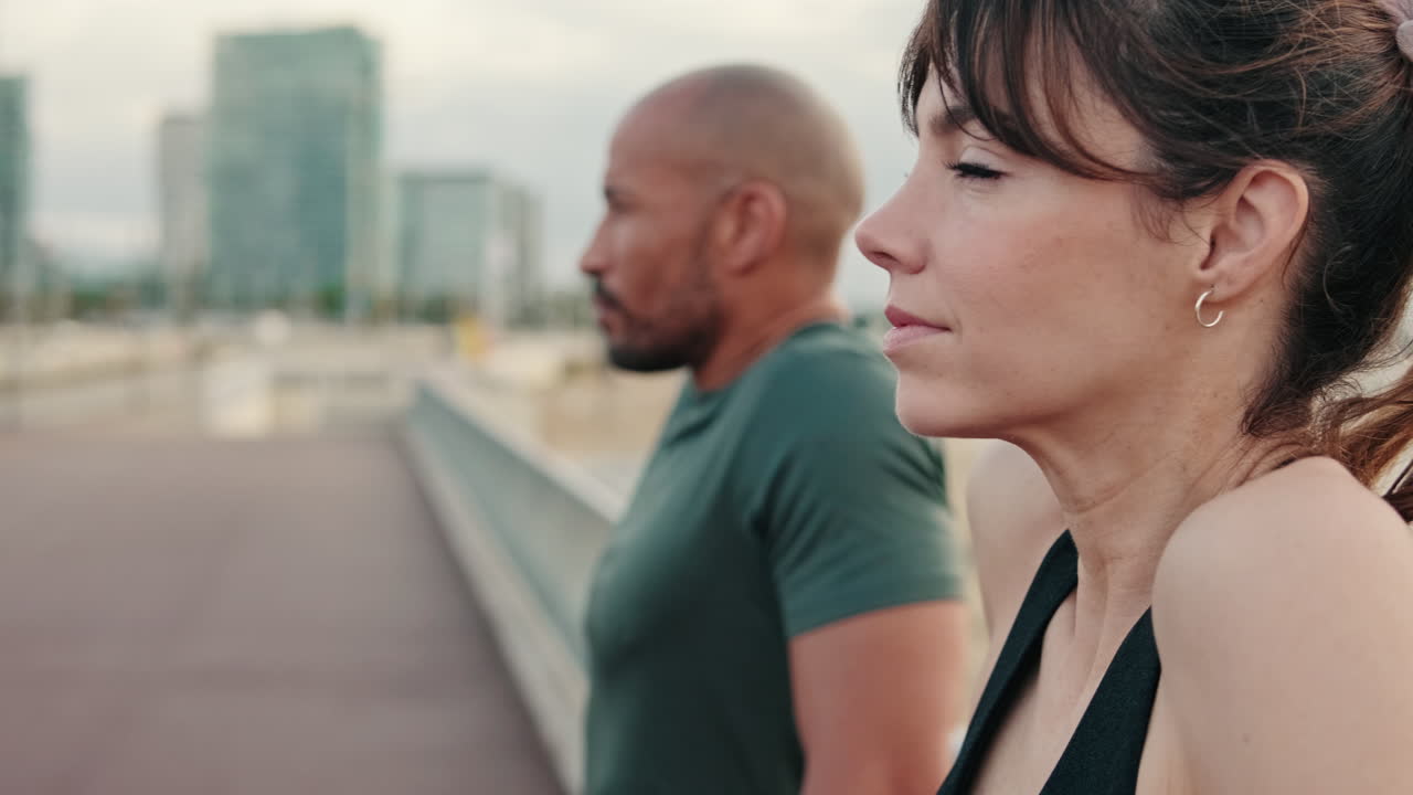 Uomo e donna atletici in piedi con calma all'aperto in ambiente urbano.