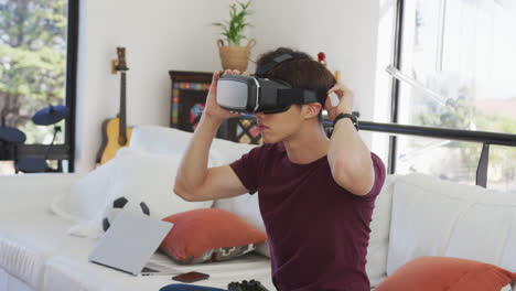 chico asiático usando auriculares vr jugando videojuegos en casa