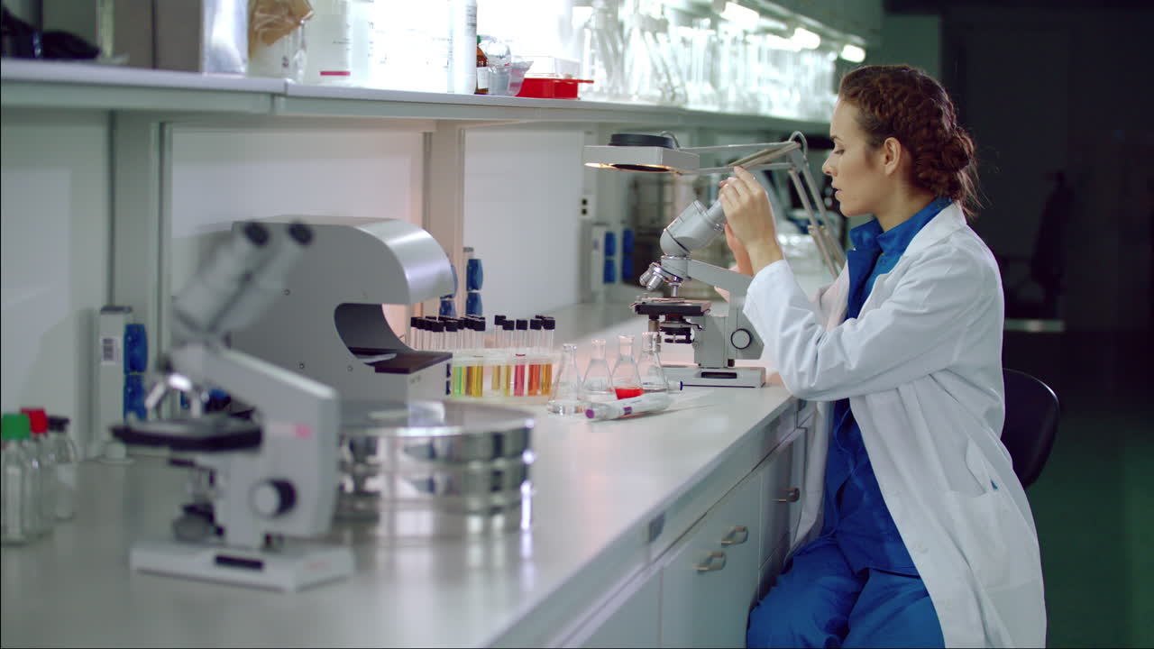 mujer científica comienza a trabajar con el microscopio. microbiólogo mirando el microscopio