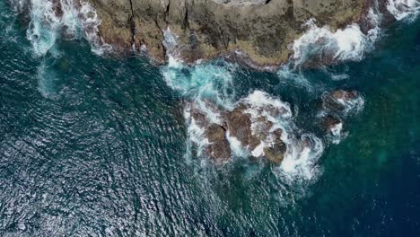 panorámica aérea de un avión no tripulado de las olas que se rompen en una costa rocosa