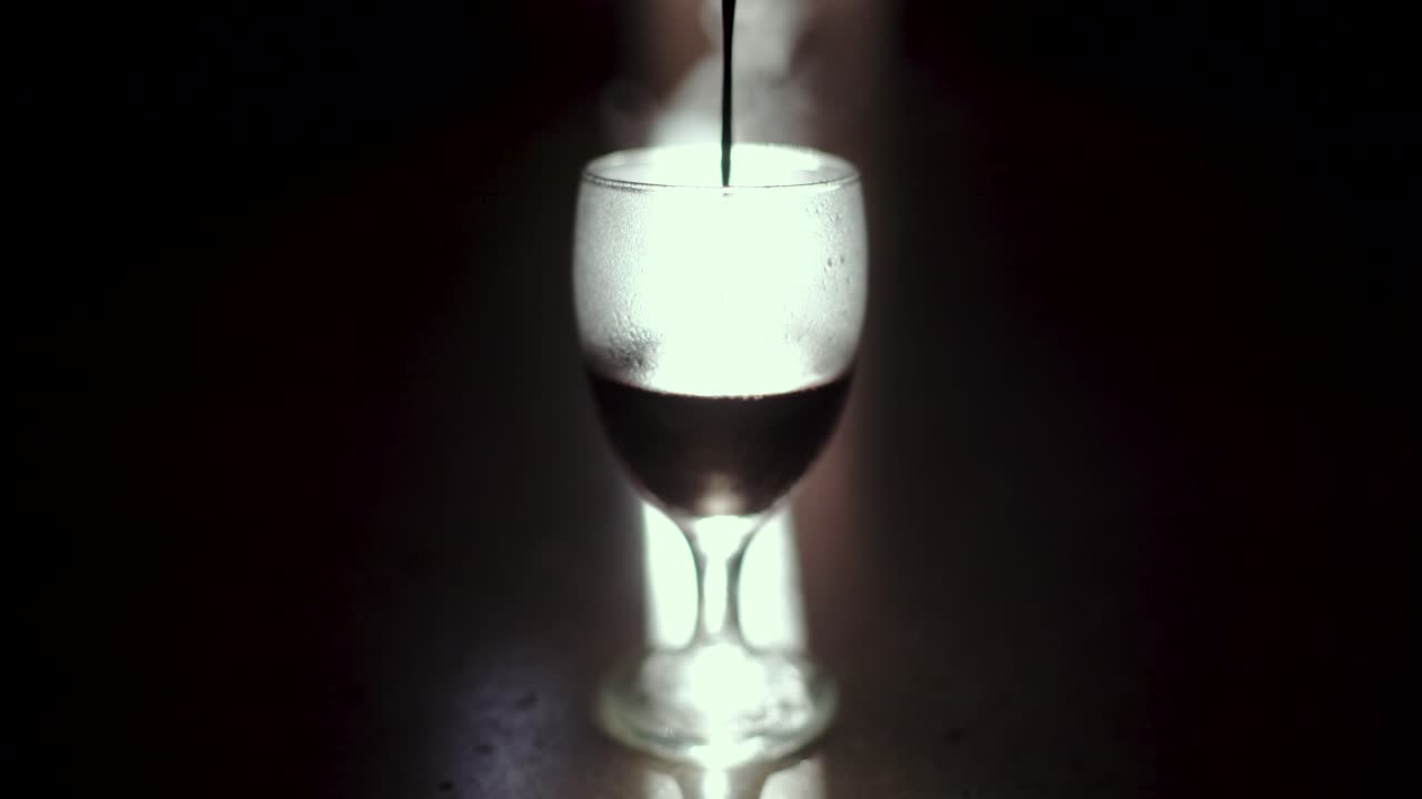 verter chocolate caliente en vidrio congelado sobre un rayo de luz