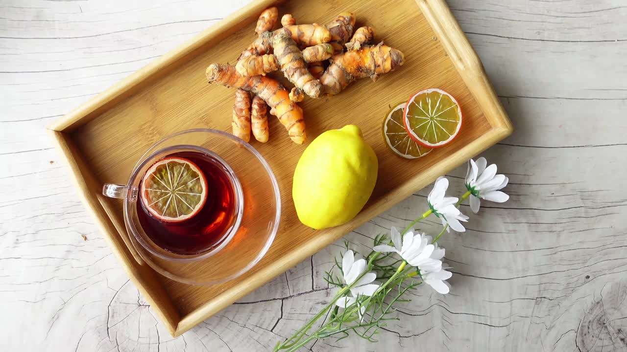 Tè alla curcuma e limone su un vassoio di legno