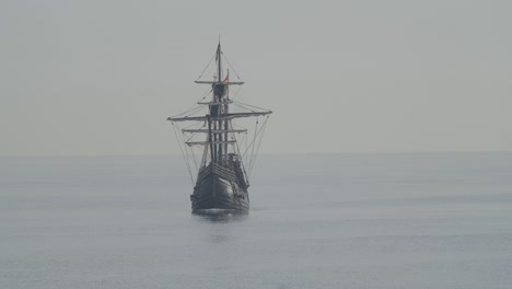 ferdinand magellan nao victoria carrack boat replica with spanish flag sails in the mediterranean at sunrise in calm sea front shot in slow motion 60fps