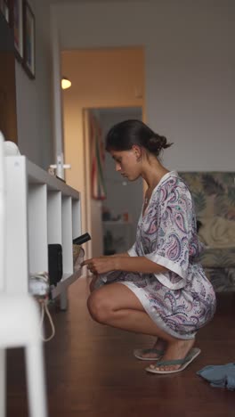 woman checking shelf in living room