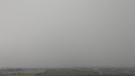 dark rain and stormy clouds over cityscape, time lapse static view