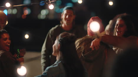 amigos felices bailando celebrando en la azotea por la noche disfrutando de la fiesta fin de semana divirtiéndose socializando pasando el rato bebiendo alcohol un grupo joven de personas celebra la reunión