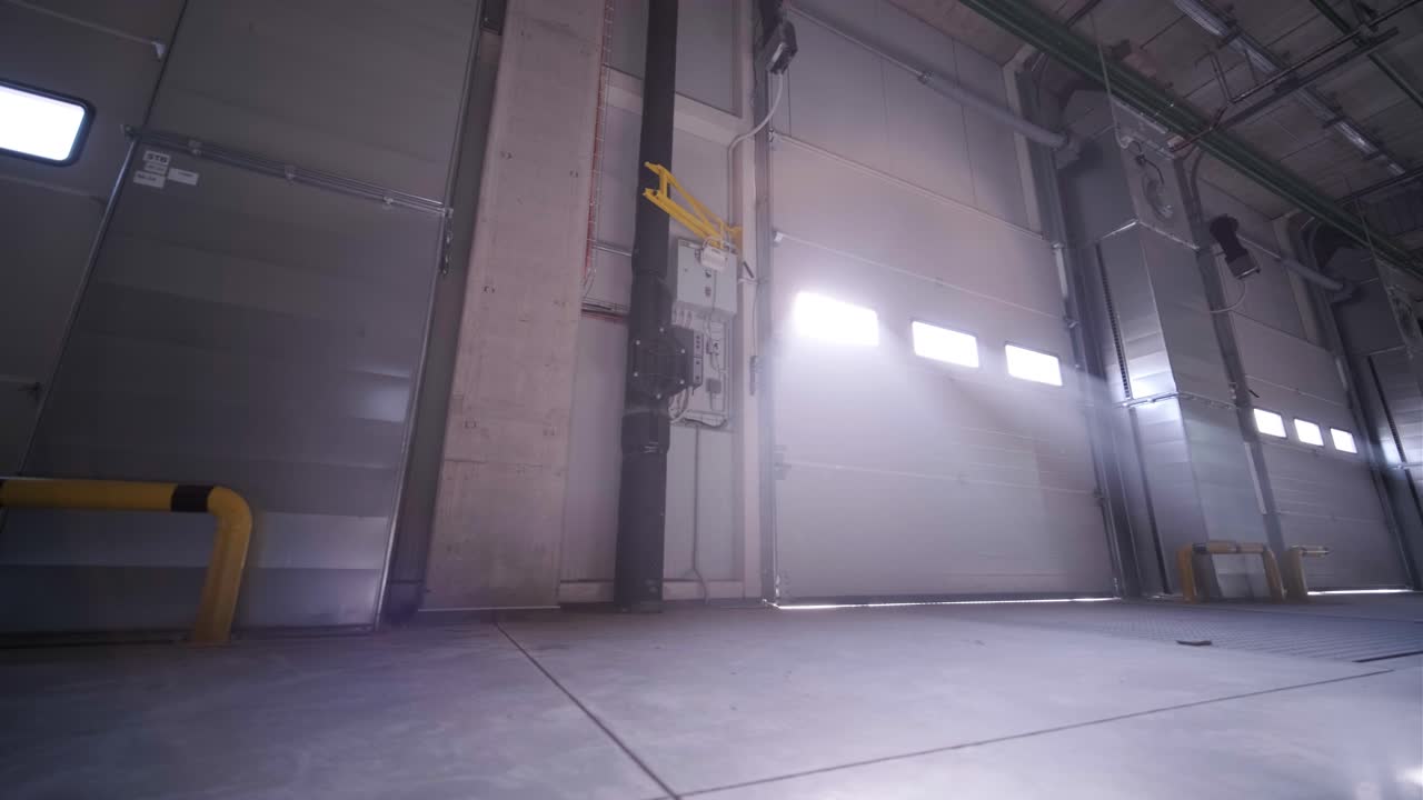 процесс строительства большого, современного склада с несколькими гаражными воротами для легкого доступа и транспортировки товаров.