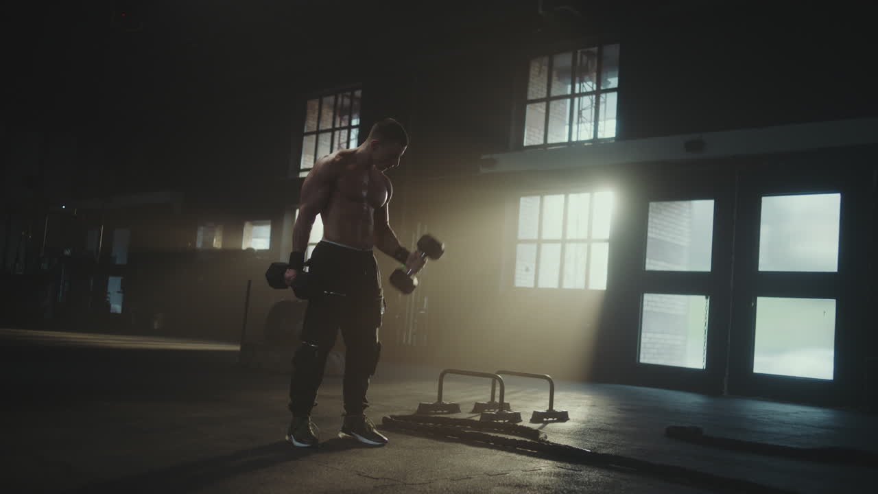 Man Doing Dumbbell Bicep Curls in a Gym