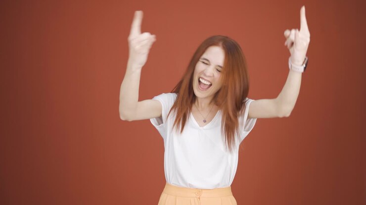Donna che fa il segno delle corna e balla